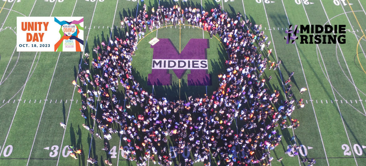 Photos shows hundreds of high school students circled around the Middies logo on midfield of a soccer field, taken from drone in the sky